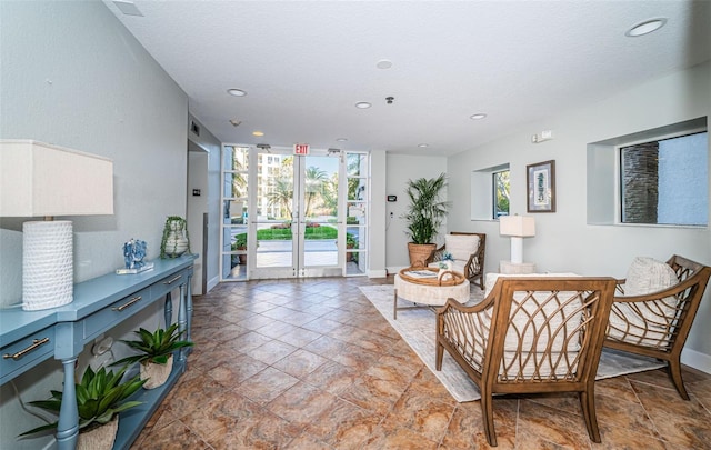 sitting room with expansive windows, baseboards, and recessed lighting