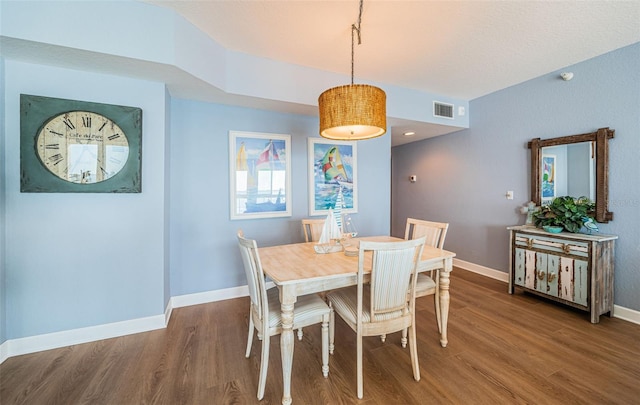 dining area with visible vents, baseboards, and wood finished floors