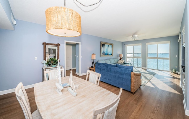 dining space with ceiling fan, wood finished floors, and baseboards