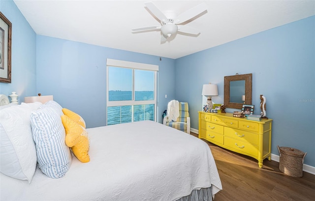 bedroom featuring wood finished floors, a ceiling fan, and baseboards