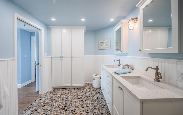 full bath featuring a wainscoted wall, a sink, and recessed lighting