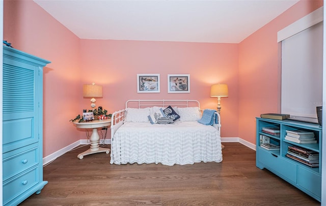 bedroom featuring wood finished floors and baseboards