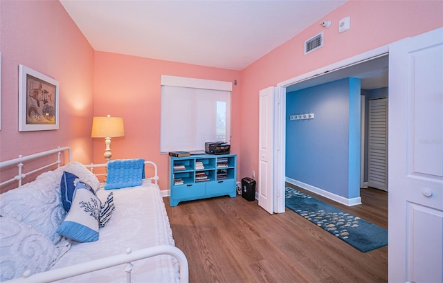 bedroom featuring baseboards, visible vents, and wood finished floors