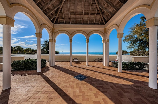 view of patio / terrace featuring a water view and a beach view