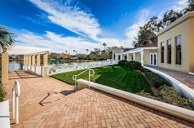 view of yard with a community pool, fence, french doors, a pergola, and a patio area