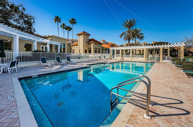 community pool featuring a patio area, fence, and a pergola