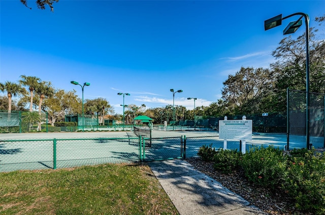 view of tennis court with fence and a gate