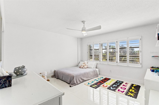 bedroom with a ceiling fan, baseboards, and a textured ceiling