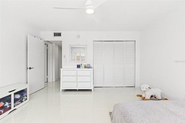 bedroom with a ceiling fan, visible vents, a closet, and light tile patterned flooring