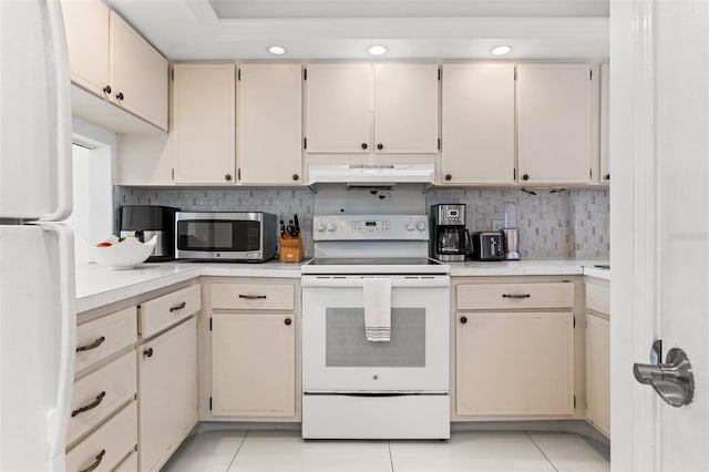 kitchen featuring white appliances, tasteful backsplash, under cabinet range hood, and light countertops