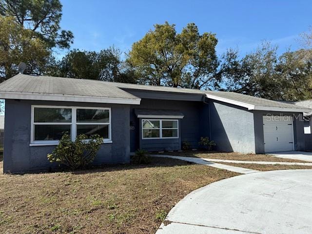 view of front of house with a garage, a front yard, and stucco siding