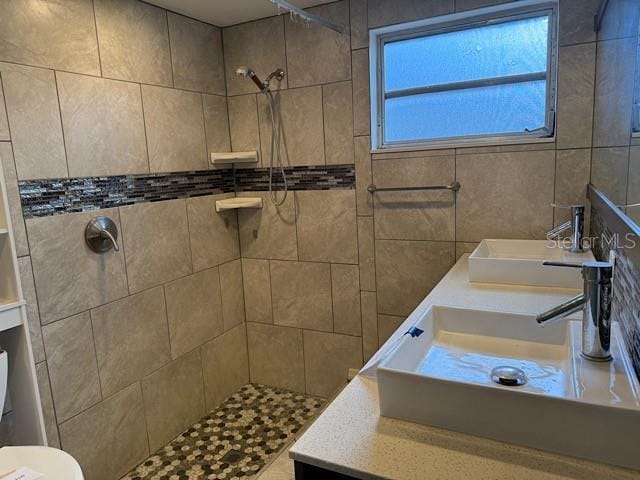 bathroom with toilet, walk in shower, and a sink