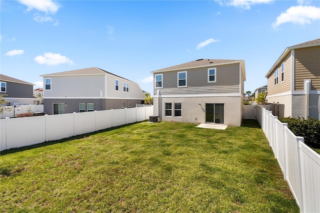 back of property with cooling unit, a fenced backyard, a yard, and a residential view