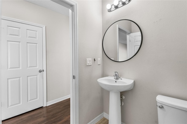 bathroom featuring wood finished floors, toilet, and baseboards