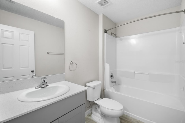 full bath featuring a textured ceiling, toilet, bathing tub / shower combination, vanity, and visible vents