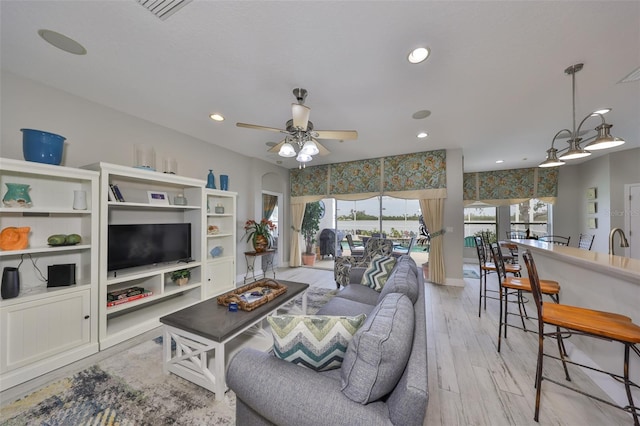 living area featuring visible vents, a ceiling fan, light wood-style flooring, and recessed lighting