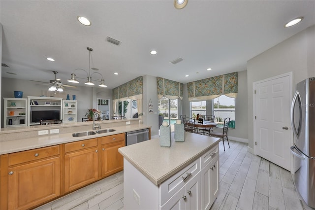 kitchen featuring light countertops, visible vents, appliances with stainless steel finishes, white cabinetry, and a sink