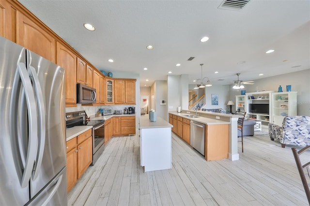 kitchen with a center island, stainless steel appliances, light countertops, hanging light fixtures, and glass insert cabinets