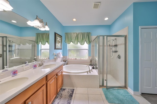 bathroom featuring a bath, a stall shower, visible vents, and a sink