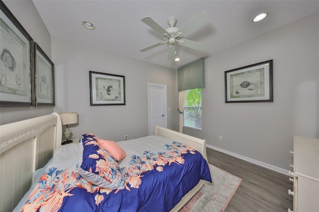 bedroom with ceiling fan, a textured ceiling, recessed lighting, wood finished floors, and baseboards