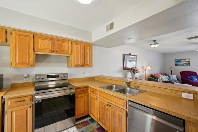 kitchen featuring visible vents, stainless steel appliances, a sink, and light countertops