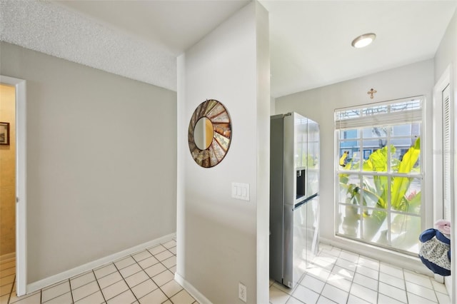 interior space with light tile patterned floors and baseboards