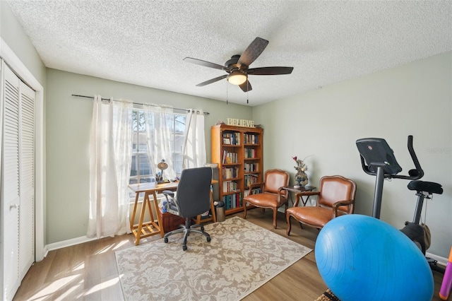 office space featuring a ceiling fan, a textured ceiling, and wood finished floors