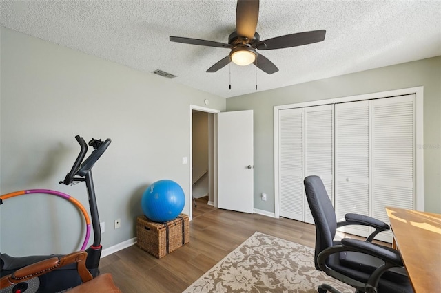 home office with baseboards, visible vents, ceiling fan, wood finished floors, and a textured ceiling