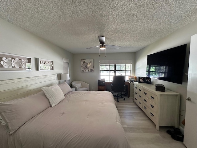 bedroom with ceiling fan, a textured ceiling, and light wood-type flooring