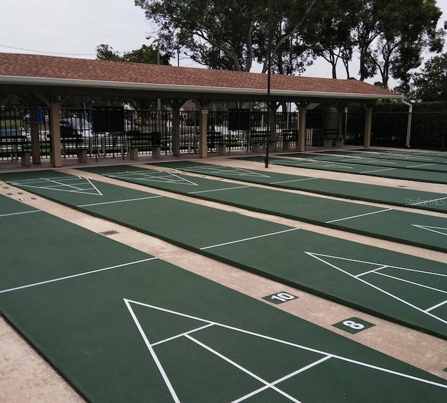 view of home's community featuring fence and shuffleboard