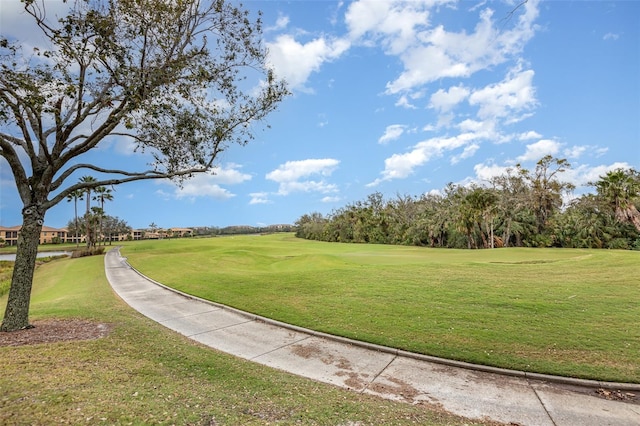 surrounding community with a yard and golf course view