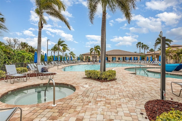 pool with a community hot tub, a patio area, and fence