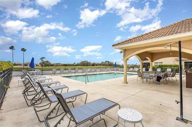 community pool with fence and a patio