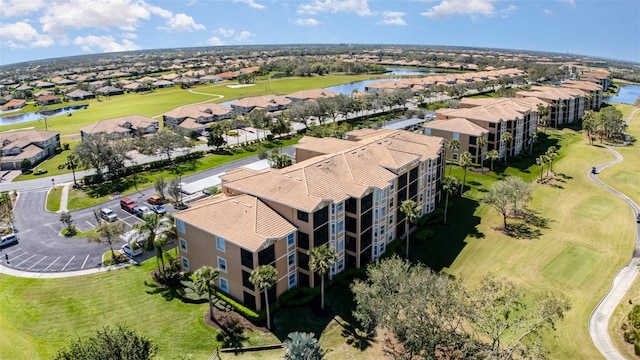 bird's eye view with golf course view, a water view, and a residential view