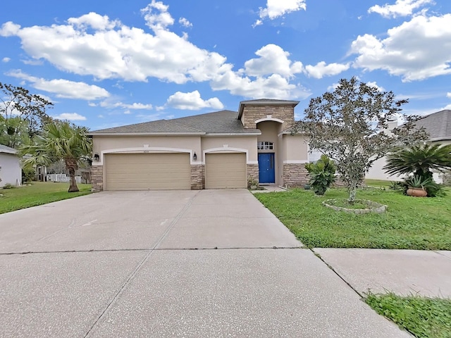 view of front of house featuring an attached garage, stone siding, concrete driveway, stucco siding, and a front yard