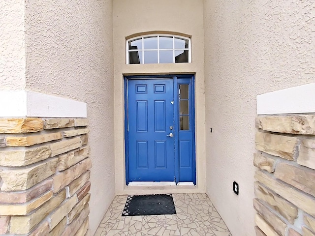 view of exterior entry with stucco siding