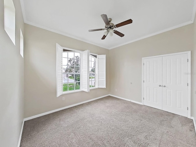 unfurnished bedroom with ornamental molding, a closet, carpet, and baseboards