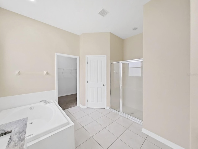 full bathroom featuring a stall shower, visible vents, tile patterned floors, a garden tub, and a spacious closet