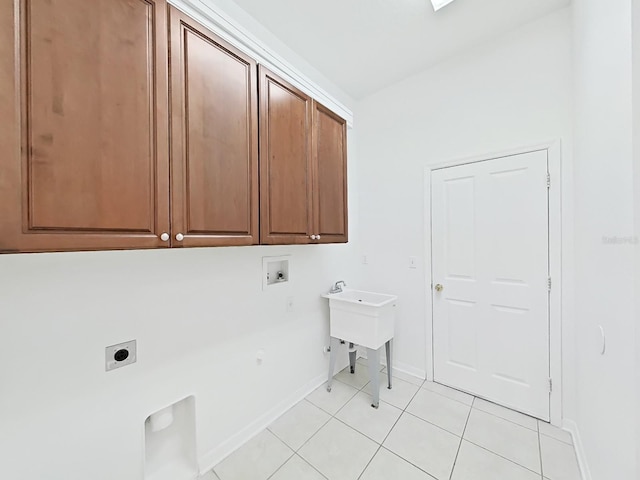 clothes washing area featuring cabinet space, light tile patterned floors, baseboards, hookup for a washing machine, and electric dryer hookup