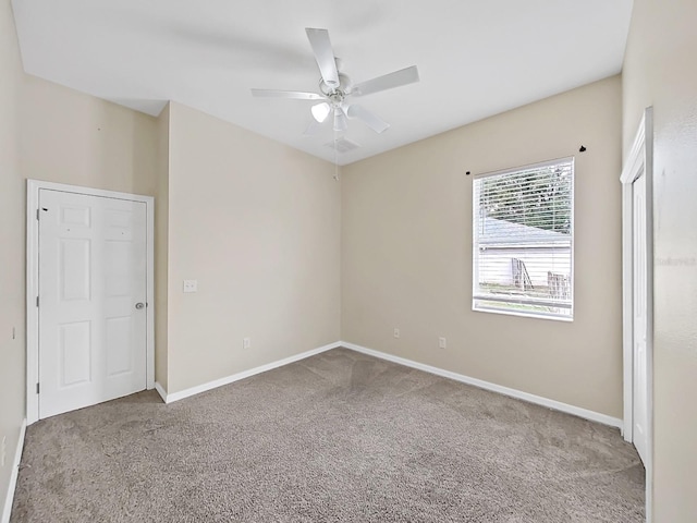 empty room featuring carpet, ceiling fan, and baseboards