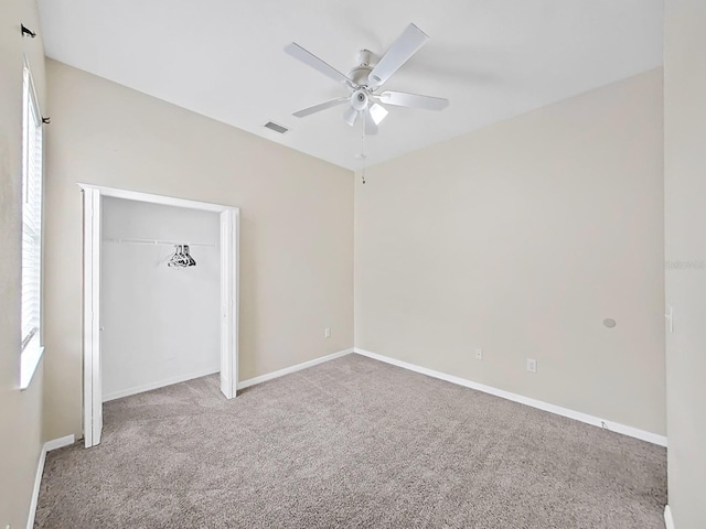 unfurnished bedroom with ceiling fan, visible vents, baseboards, a closet, and carpet