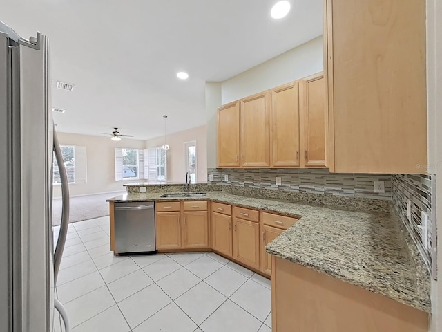 kitchen with visible vents, a peninsula, stainless steel appliances, a sink, and light tile patterned flooring