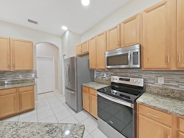 kitchen with visible vents, appliances with stainless steel finishes, arched walkways, and light brown cabinetry