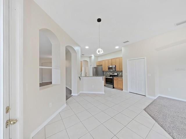 kitchen with appliances with stainless steel finishes, open floor plan, decorative backsplash, and light countertops