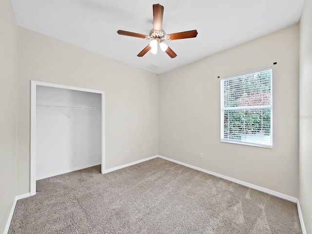 unfurnished bedroom with carpet floors, a ceiling fan, baseboards, and a closet