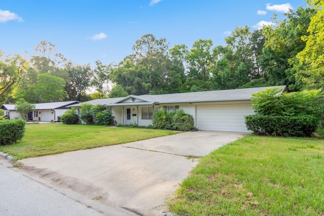 ranch-style home featuring an attached garage, driveway, and a front lawn