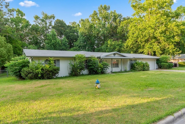 ranch-style house with a front lawn, fence, and an attached garage