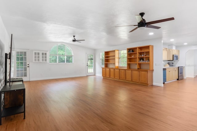 unfurnished living room with ceiling fan, light wood-type flooring, lofted ceiling, and baseboards