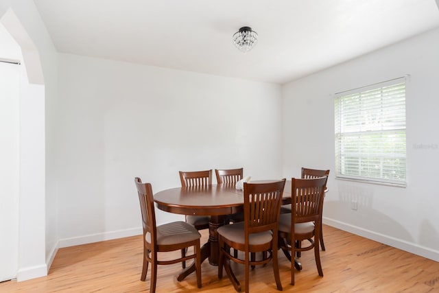 dining room featuring light wood finished floors and baseboards