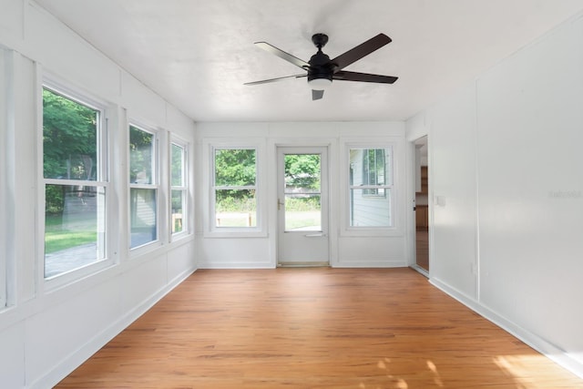 unfurnished sunroom featuring a ceiling fan